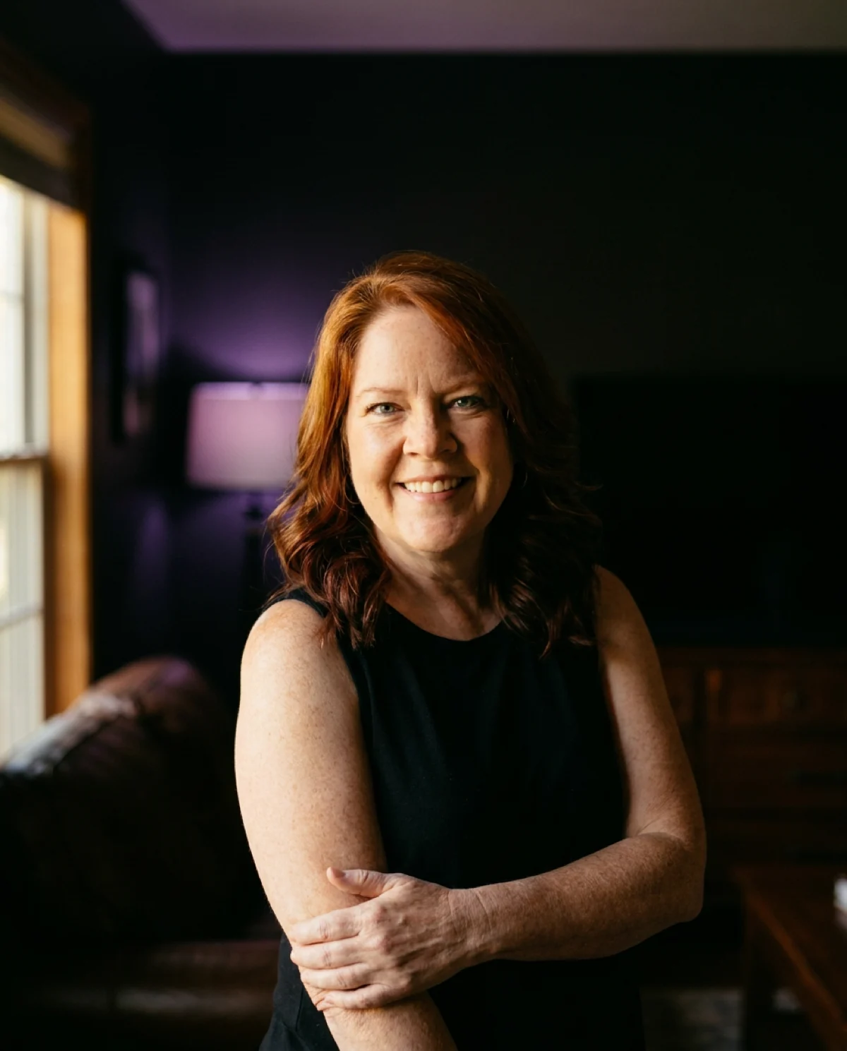 Michelle Anderson sourit dans une pièce à la lumière chaude